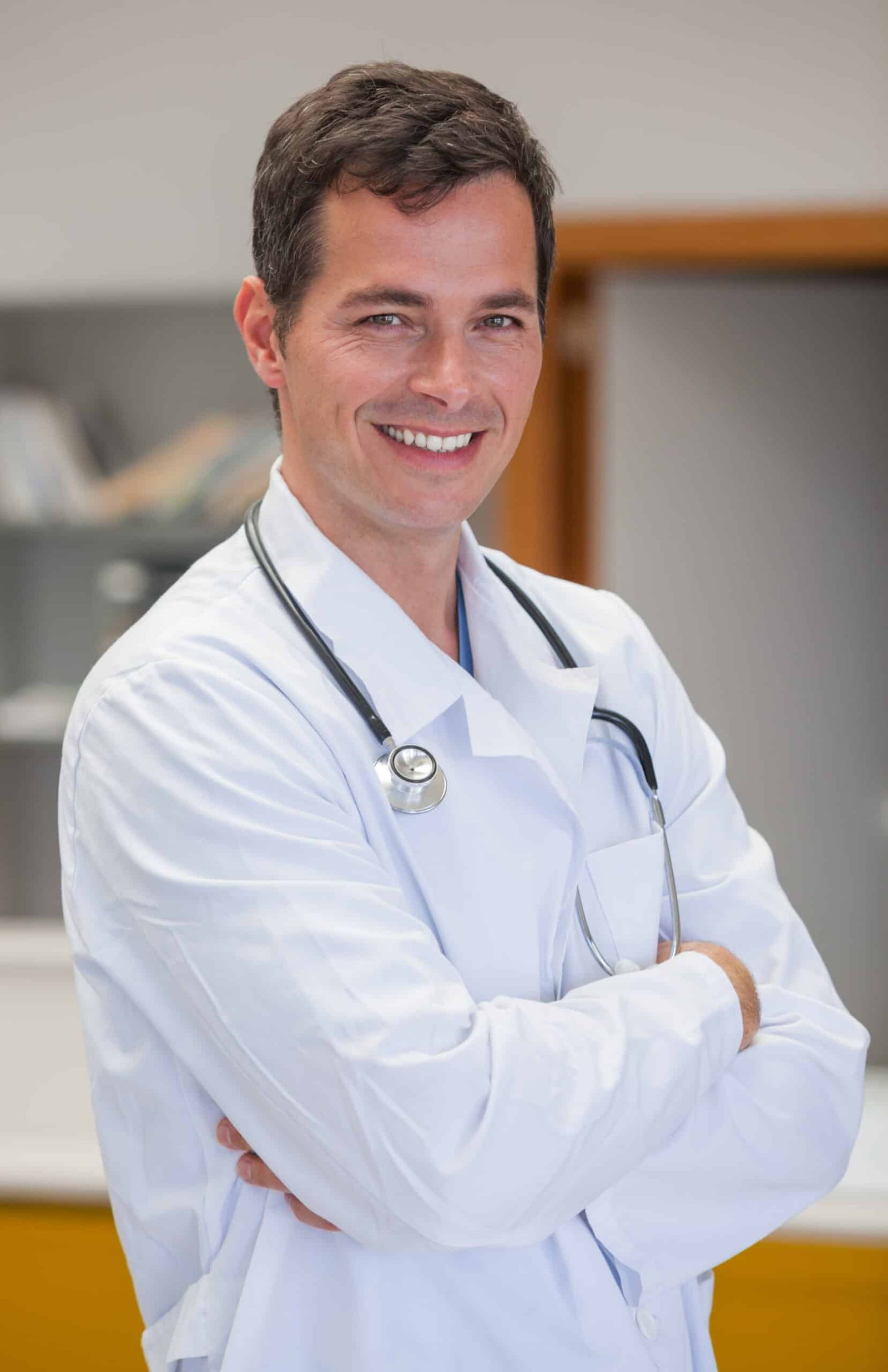 Smiling doctor with arms crossed in hospital reception