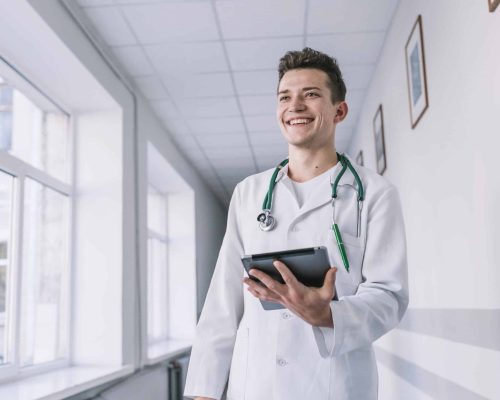 cheerful-young-doctor-with-tablet-hall cheerful-young-doctor-with-tablet-hall
